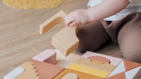 a baby is playing with wooden blocks on the floor