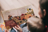 a woman is reading a book to her baby